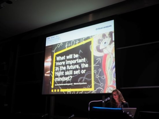 A photograph of Agathe Jarczyk presenting in a dark room with a large projection screen
