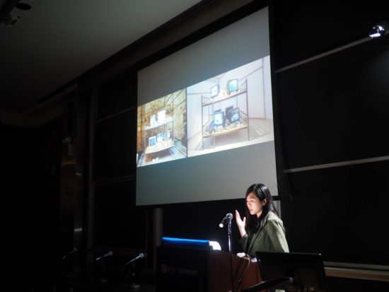 A photograph of Shu-Wen Lin presenting a slide-show
