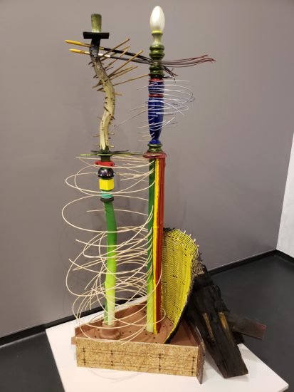 A photograph of a multi-colored abstract sculpture made of various materials