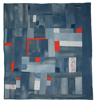 A hand-made quilt of denim patchwork fabric with red and floral fabric interspersed